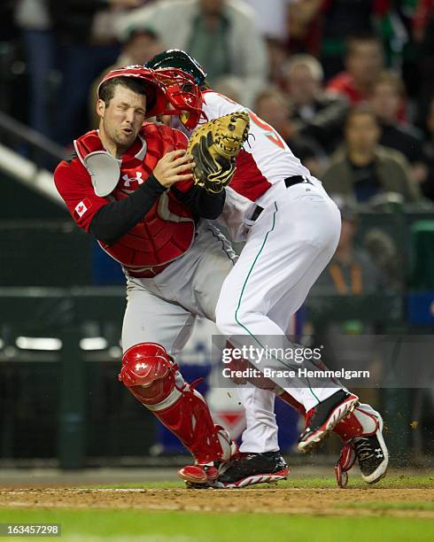 Karim Garcia of Mexico collides with Chris Robinson of Canada at home plate during the World Baseball Classic First Round Group D game on March 9,...