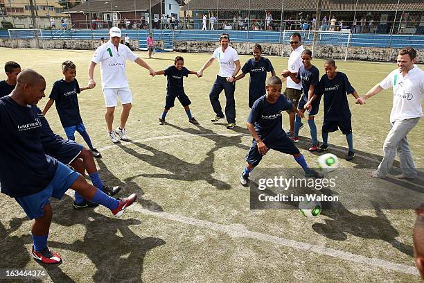 Laureus Ambassador Axel Schulz plays football with the local children at the Mercedes-Benz Sprinter handover to the Bola Project during 2013 Laureus...