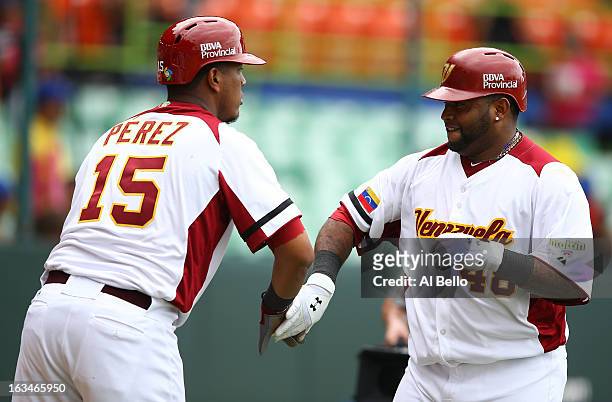 Pablo Sandoval of Venezuela celebrates his home run with Salvador Perez after hitting a home run against Spain during the first round of the World...