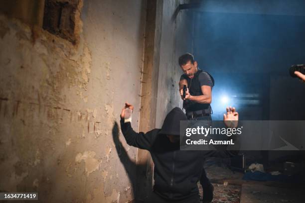 handsome detective pointing at a criminal with a fire gun - fbi arrest stock pictures, royalty-free photos & images