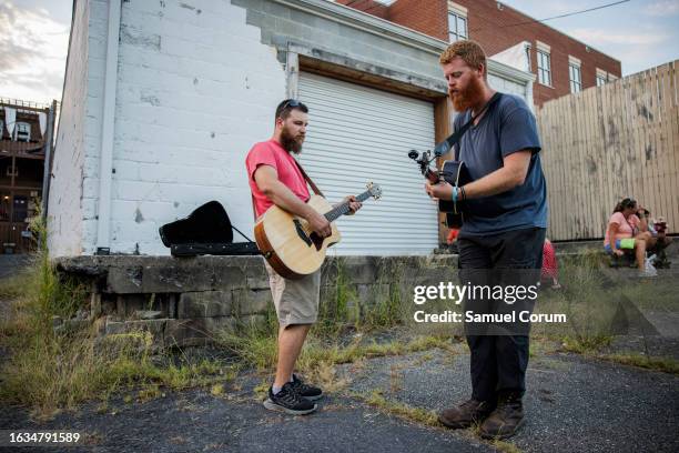 Christopher Anthony Lunsford , who goes by the stage name Oliver Anthony, warms up with his guitarist Joey Davis next to a loading dock behind the...
