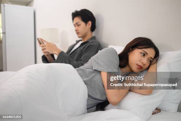 the asian couple getting upset with each other in bedroom. - suspicion infidelity stock pictures, royalty-free photos & images