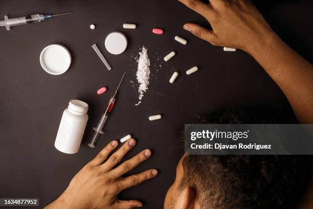 man lying on a table due to drug overdose. drug addiction concept. - heroin stock-fotos und bilder