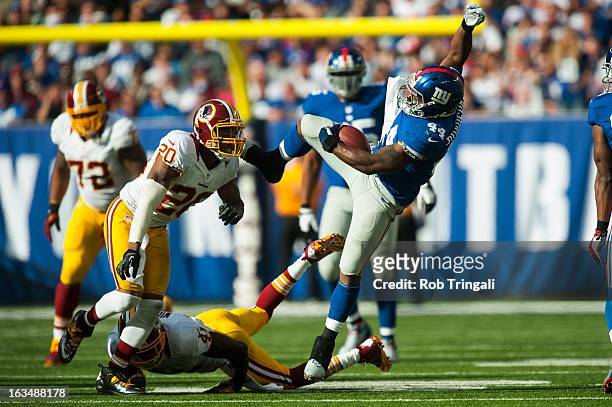 Running back Ahmad Bradshaw of the New York Giants looses his balance after being tripped by free safety Madieu Williams of the Washington Redskins...