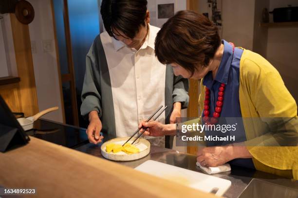 a grandmother teaches her grandson traditional cooking. - fashionable grandma stock pictures, royalty-free photos & images