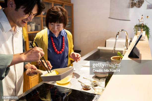 a grandmother teaches her grandson traditional cooking. - fashionable grandma stock pictures, royalty-free photos & images