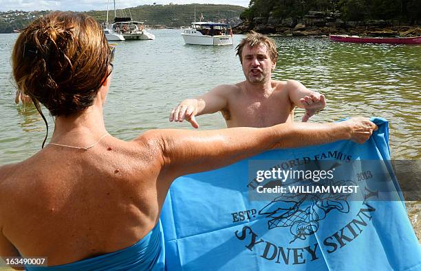 Organizer Nigel Marsh reaches for a sarong after completing the "Sydney Skinny" - in what is dubbed the first mass nude ocean swim, in Sydney on...