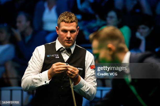 Daniel Wells of Wales chalks the cue in the second round match against Shaun Murphy of England on day 2 of Snooker European Masters 2023 at Kia...