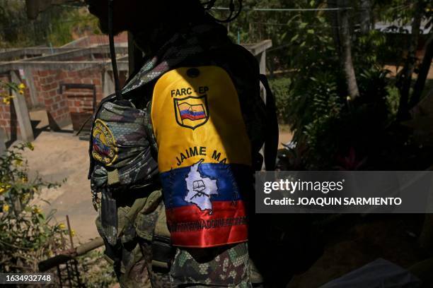 Guerrilla fighter from the FARC dissidence Jaime Martinez stands guard as commander Andrey gives an interview near the town of Suarez, department of...