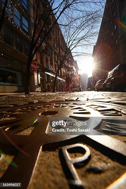sun shining to stone pavement street and manhole - マンホール ストックフォトと画像