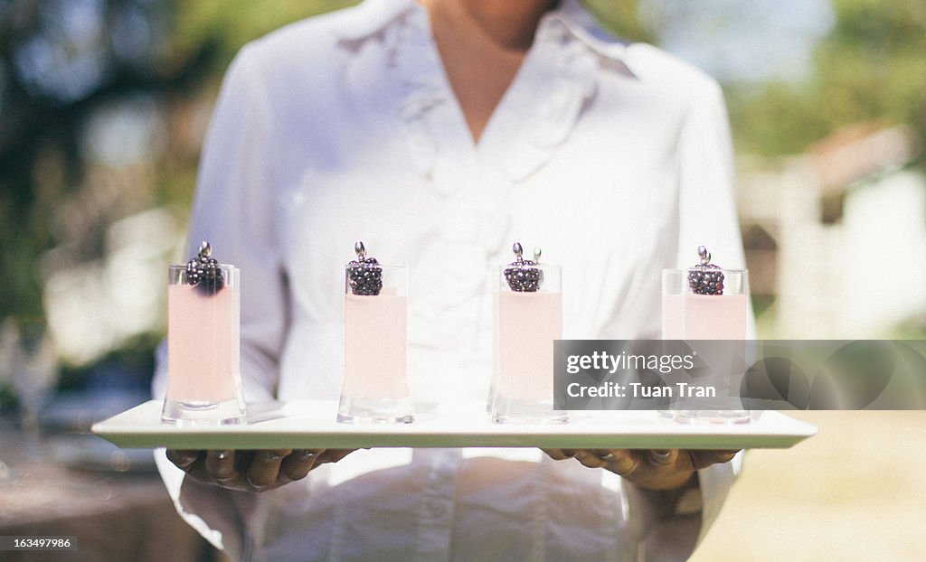 Waiter holding multiple glasses at wedding