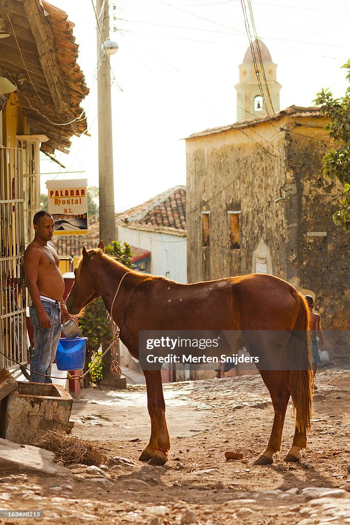 Man providing water for horse