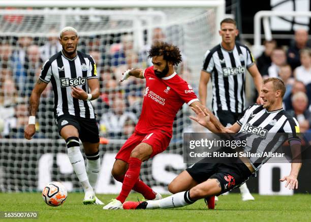 Mohamed Salah of Liverpool and Dan Burn of Newcastle United challenge during the Premier League match between Newcastle United and Liverpool FC at...