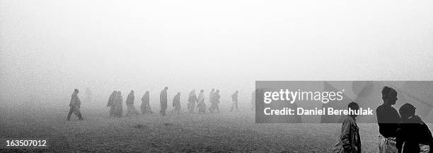 Hindu devotees walk through mist towards the banks of the holy Ganges river as people gather ahead of the Maha Kumbh Mela on January 13, 2013 in...