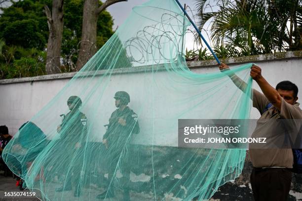 Man sells a mosquito net during a fumigation campaign against the Aedes aegypti mosquito, a vector of the dengue, Zika, and Chikungunya viruses, as a...