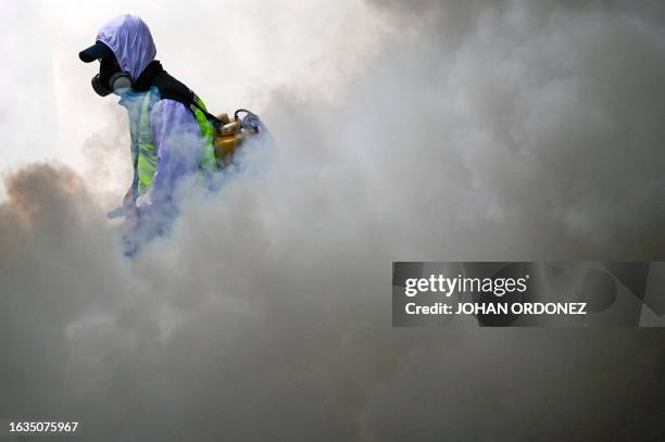 Municipal worker fumigates against the Aedes aegypti mosquito, a vector of the dengue, Zika, and Chikungunya viruses, as a preventive measure outside...