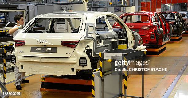 An employee of the German car maker Audi works on a new Audi A3 at the production line in the car factory in Ingolstadt, southern Germany, on March...