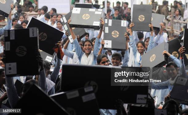 Excited students from a city college after receiving free Laptops on March 11, 2013 in Lucknow, India. Akhilesh Yadav launched the free laptop scheme...