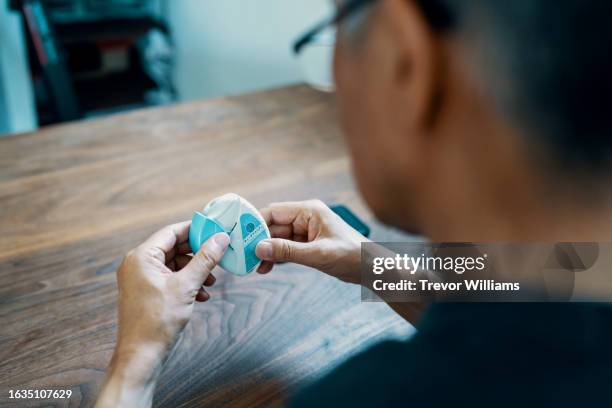senior man using an inhaler for respiratory disease - inhalador-preventivo-del-asma fotografías e imágenes de stock