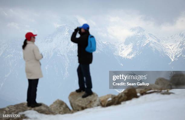 Visitors look out at the Bucegi mountains from the Poiana Brasov ski resort on March 9, 2013 at Poiana Brasov, Romania. Romania is eager to promote...