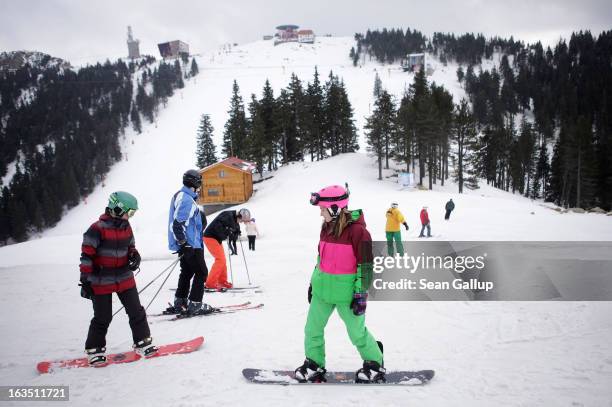 Skiers and snowboarders take in late winter pistes in the Bucegi mountains on March 9, 2013 at Poiana Brasov, Romania. Romania is eager to promote...