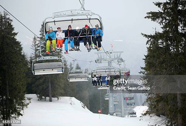 Skiers ride a chairlift at the Poiana Brasov ski resort in the Bucegi mountains on March 9, 2013 at Poiana Brasov, Romania. Romania is eager to...