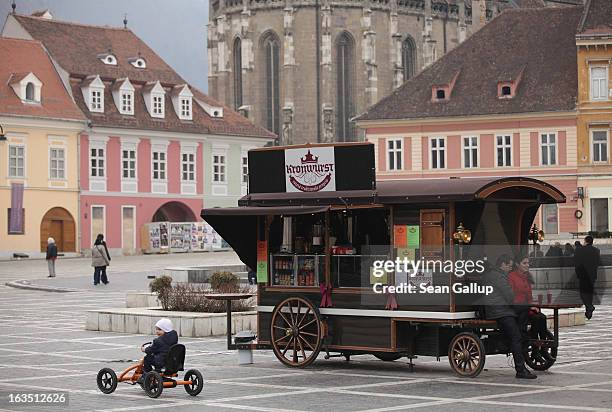 Weekend visitors relax in Sfatului square next to Saxon-built houses in the historic district on March 9, 2013 in Brasov, Romania. Brasov, in German...