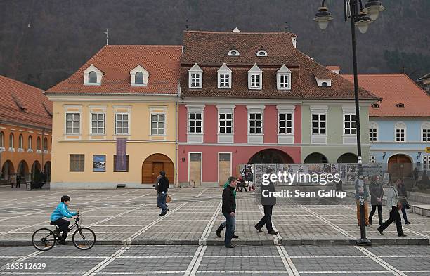 Weekend visitors relax in Sfatului square next to newly-renovated Saxon-built houses in the historic district on March 9, 2013 in Brasov, Romania....
