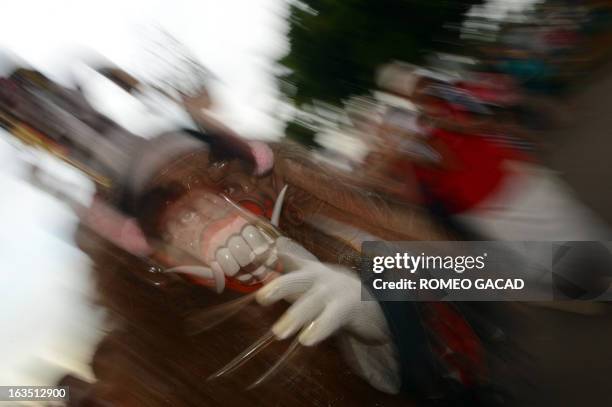 Devotee of Indonesia's Hindu minority wears a mask during a parade of "Ogoh Ogoh" effigies at Jakarta's central National Monument on March 11, 2013...