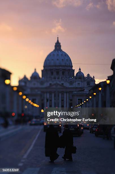 Priests make their way home as night time falls over St Peter's Basilica and catholic cardinals prepare to enter the conclave tomorrow and elect a...