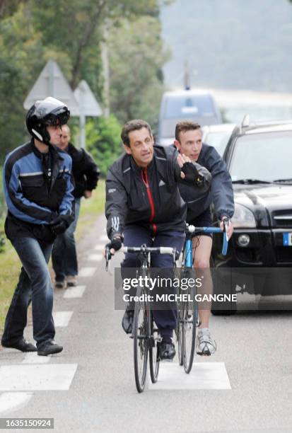 French president Nicolas Sarkozy arrives on his bike to his wife, Carla Bruni-Sarkozy's residency on April 12, 2009 in the French city of Cavaliere,...