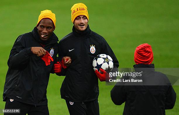 Didier Drogba jokes with team mate Albert Riera during a Galatasaray AS training session ahead of their UEFA Champions League round of 16 match...