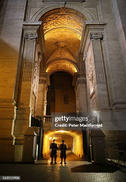 Members of The Swiss Guard stand at the Arch of the Bells at St Peter's Basilica on March 11, 2013 in Vatican City, Vatican. Cardinals are set to...