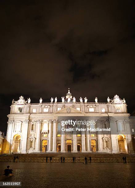 Few pilgrims are present in front of St Peter's Basilica as night falls on March 11, 2013 in Vatican City, Vatican. Cardinals are set to enter the...