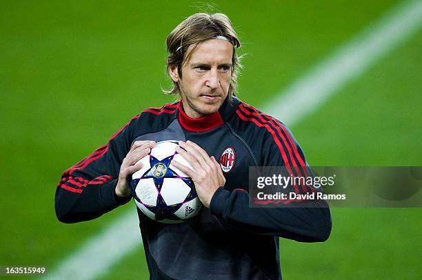 Massimo Ambrosini of AC Milan holds the ball during the training session ahead of their UEFA Champions League round of 16 second leg against FC...