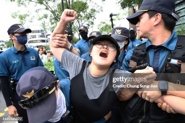 South Korean university student is detained by police officers on an attempt to break into the Japanese embassy on August 24, 2023 in Seoul, South...