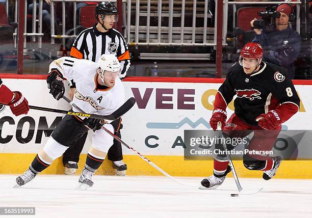 Saku Koivu of the Anaheim Ducks and Matthew Lombardi of the Phoenix Coyotes skate after the puck during the NHL game at Jobing.com Arena on March 4,...