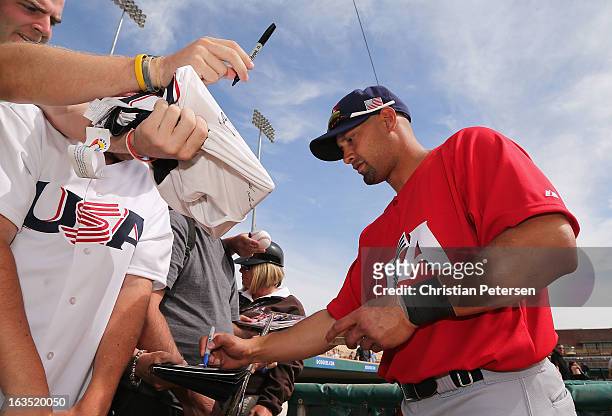 Shane Victorino of USA signs autographs for fans before the spring training game against the Chicago White Sox at Camelback Ranch on March 5, 2013 in...
