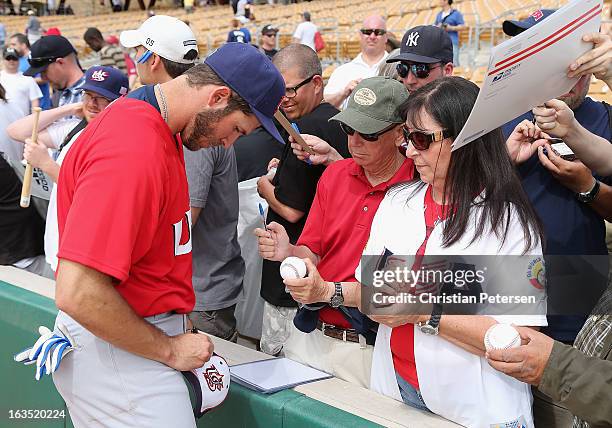 Arencibia of USA signs autographs for fans before the spring training game against the Chicago White Sox at Camelback Ranch on March 5, 2013 in...