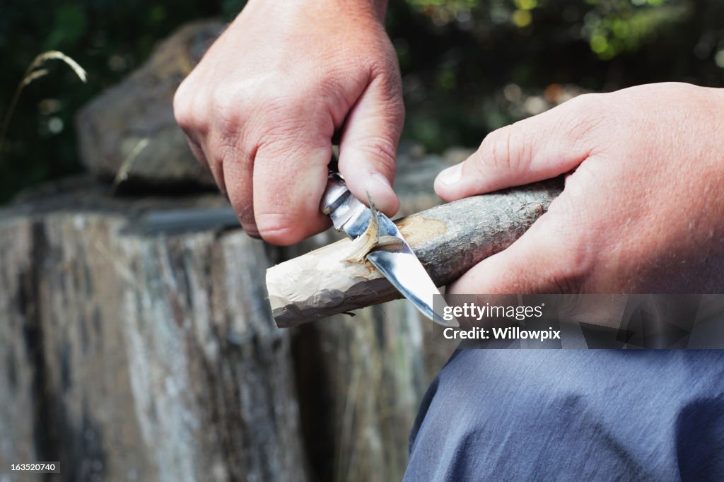 Man Carving Wooden Stick