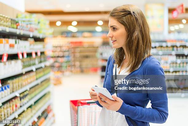 checking shopping list - shoppers ahead of consumer price index stockfoto's en -beelden
