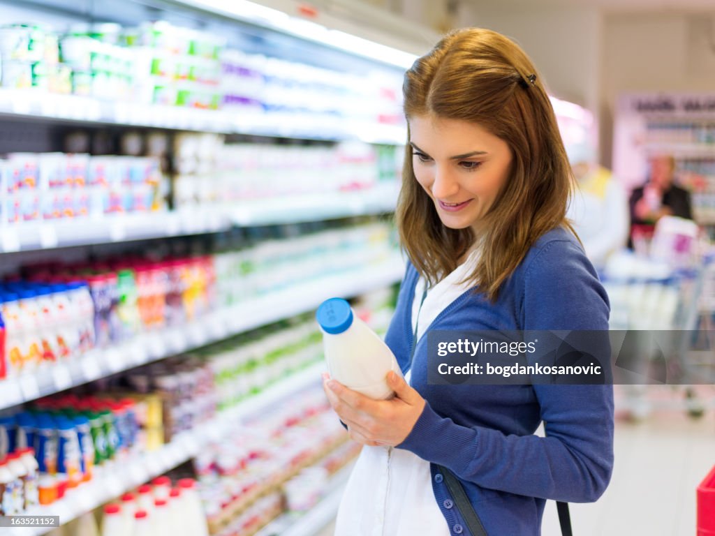 Mujer de compras en el supermercado leche