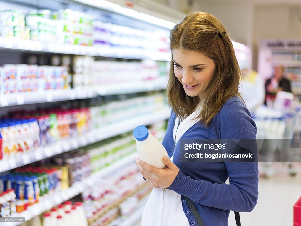 Female buying milk in supermarket