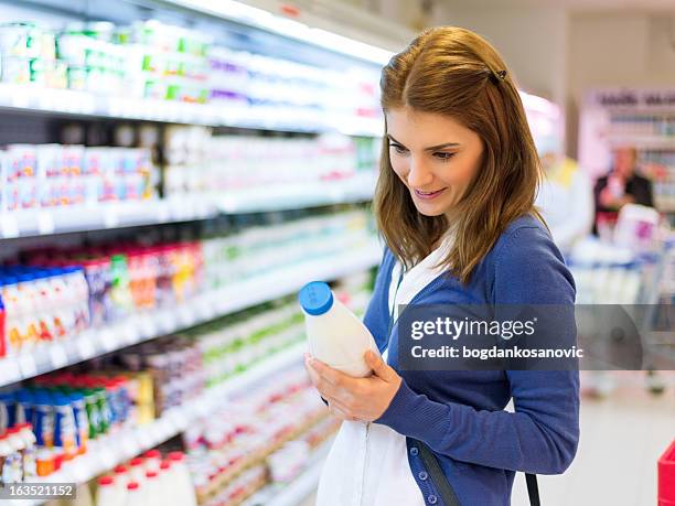 female buying milk in supermarket - milk pack 個照片及圖片檔