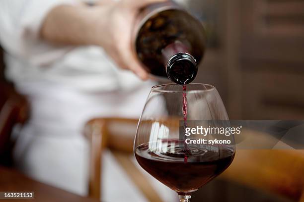 versare un drink - red wine foto e immagini stock