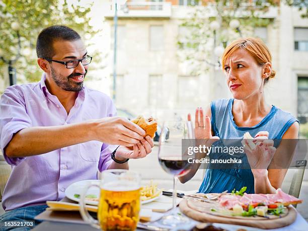 couple eating in outdoors cafe: woman refuses to eat burger - refusing stock pictures, royalty-free photos & images