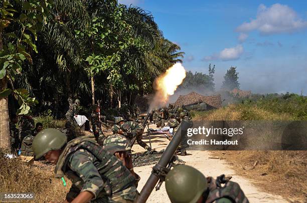 In this handout image provided by the Malaysia Ministry of Defence, Malaysian soldiers fire mortar rounds toward Filipino gunmen during a standoff on...