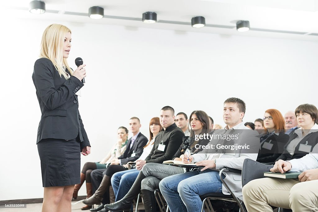 Young businesswoman with microphone