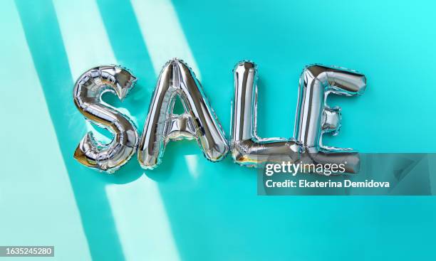 sale inscription from silver balloons on a turquoise background - metallic balloons stock pictures, royalty-free photos & images