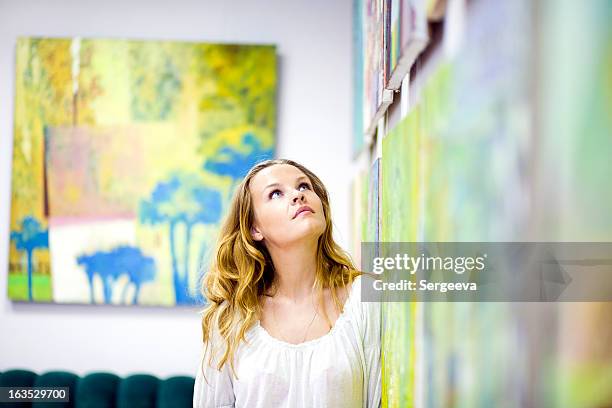 woman gazing at artwork on the wall - exhibition stock pictures, royalty-free photos & images